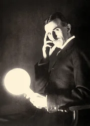 Portrait of Nikola Tesla Holding a Light Bulb Illuminated by the Electromagnetic Field of a Tesla Coil